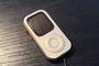 Carcasa para Apple Watch con estética de iPod clásico y botones laterales naranjas.