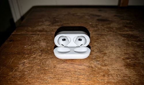 AirPods 4 con su estuche de carga USB-C sobre una superficie