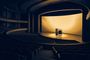 Vista panorámica de un teatro oscuro con una gran pantalla iluminada en el escenario que muestra dos smartphones, uno de ellos plegable.