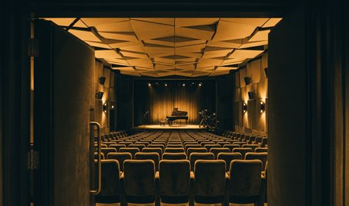 Vista desde la puerta del patio de butacas hacia el escenario con un piano de cola en el Apple Music Hall.
