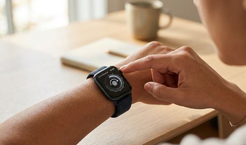Persona pulsando la corona digital de un Apple Watch Series 12 que muestra la interfaz de Live Rewind.