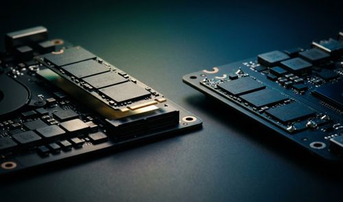 Comparación en primer plano entre una placa base con un módulo SSD M.2 intercambiable elevado y otra placa con chips de almacenamiento NAND soldados directamente en el circuito.