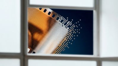Representación abstracta de un negativo de película con grano analógico desintegrándose en píxeles digitales.