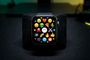 Primer plano de un Apple Watch mostrando una cuadrícula de emojis variados en su pantalla.