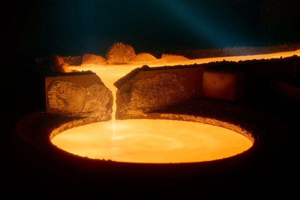Metal fundido incandescente fluyendo en un molde circular durante un proceso de fabricación industrial.