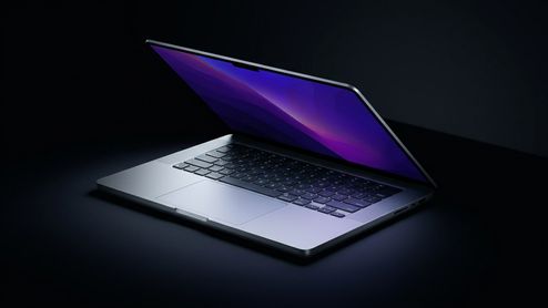 MacBook Pro de 14 pulgadas parcialmente abierto sobre una superficie oscura con fondo negro.