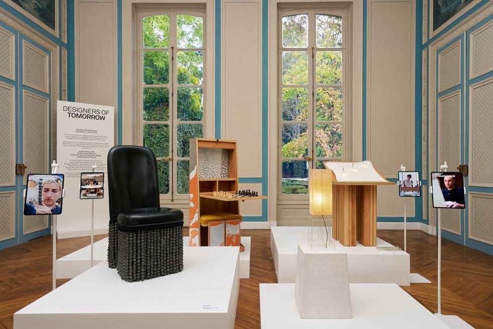 Instalación de la muestra Designers of Tomorrow 2026 con muebles de diseño y dispositivos iPad en una sala palaciega en París.