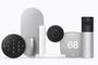 Conjunto de dispositivos Apple Home Collection que incluye cámara de seguridad, termostato digital, timbre inteligente y cerradura electrónica en tonos gris y blanco.