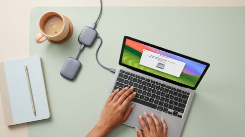 Persona utilizando un ordenador portátil MacBook con una ventana de gestión de almacenamiento abierta para liberar espacio en el disco duro.