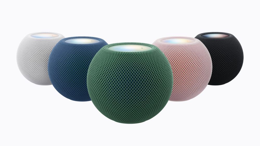 Cinco altavoces inteligentes HomePod mini 2 en colores blanco, azul, verde, rosa y negro sobre fondo blanco.
