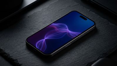 Teléfono inteligente con pantalla encendida mostrando ondas de colores sobre una superficie de piedra oscura.