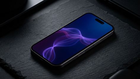 Teléfono inteligente con pantalla encendida mostrando ondas de colores sobre una superficie de piedra oscura.
