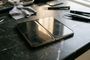 iPhone Duo abierto sobre una mesa de trabajo rodeado de herramientas de precisión y pinzas.