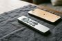 Mando Siri Remote junto a un iPhone que muestra la interfaz de búsqueda por proximidad sobre una superficie textil.